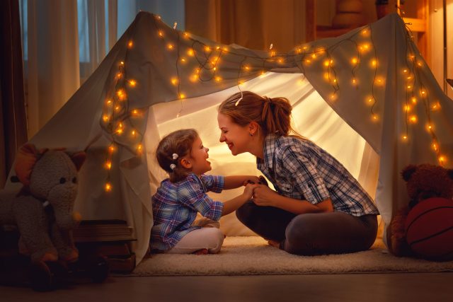 a little girl and a little girl playing in a tent.